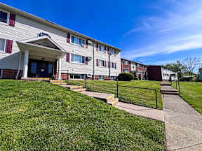 apartment building with sidewalk and stairs in front of it