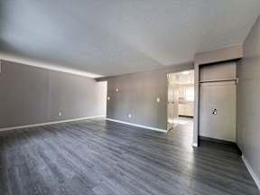 the living room of an empty apartment with wood flooring