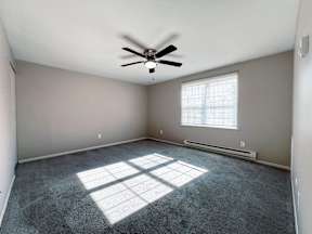 an empty room with a ceiling fan and a window