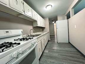a kitchen with white appliances and white cabinets and a white refrigerator