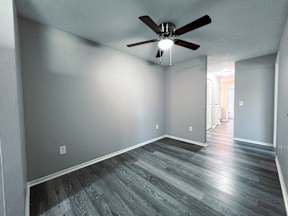 a living room with gray walls and a ceiling fan