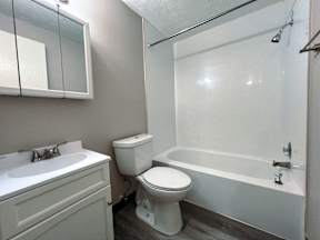 an empty bathroom with a toilet and a tub and a sink