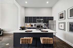 a kitchen with black cabinets and a white counter top