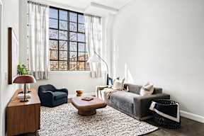 a living room with a couch and a chair and a window