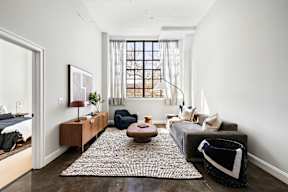 a living room with a couch and a table and a window