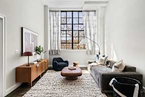a living room with a gray couch and a window