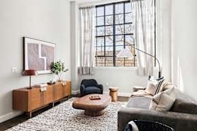 a living room with a couch and a chair and a window