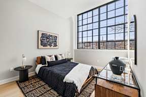a bedroom with a bed and a large window