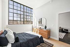 a bedroom with a bed and a large window