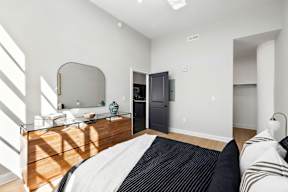 a bedroom with a bed and a dresser with a mirror