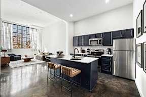 a kitchen with a center island and a stainless steel refrigerator