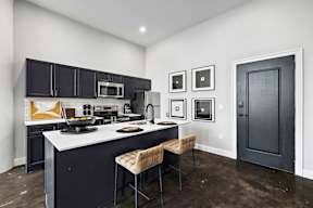 a kitchen with black cabinets and a white counter top