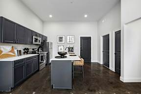 a kitchen with black cabinets and a white counter