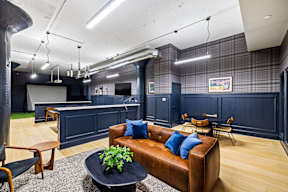 a living room with a leather couch and a kitchen
