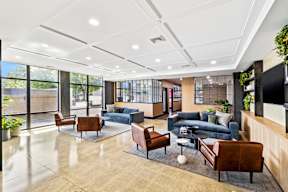 a lobby with couches and chairs and a tv