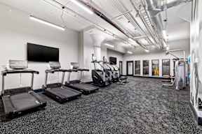 a gym with treadmills and cardio equipment in a building