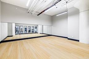 a large room with a wooden floor and paintings on the wall