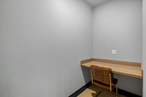 a desk and a chair in a room with white walls