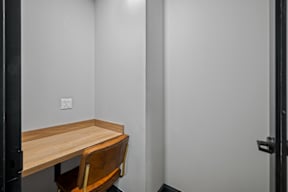 a small desk in a room with a chair