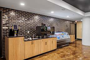 a lobby with a coffee machine and a brick wall