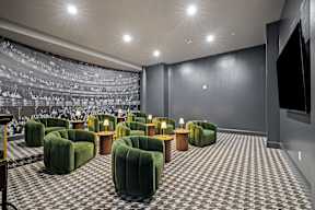 a large theater room with green chairs and a large projector screen