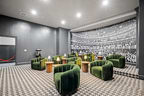 a large theater room with green chairs and a projector screen