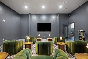 a living room with green chairs and a television