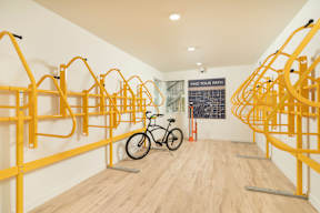 A bike is parked in a room with yellow bike racks.