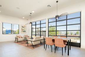 A room with a table and chairs and a fan.