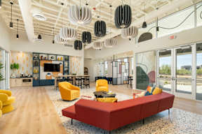 A modern living room with a red sofa and yellow chairs.