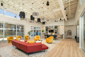 A modern living room with a red sofa and yellow chairs.