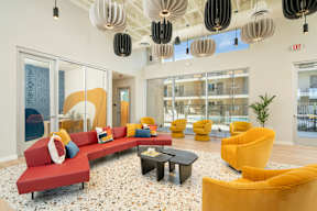 A brightly colored waiting area with a red couch and yellow chairs.