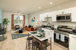 A modern kitchen with a dining table and chairs in the middle.