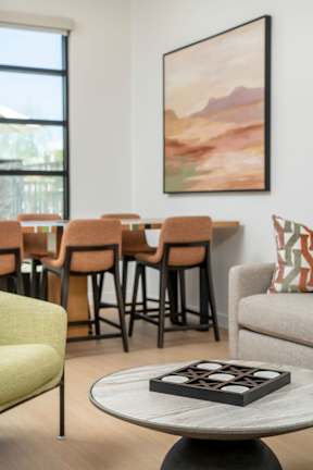 A painting hangs on the wall above a table with a game on it.