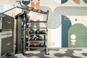 A gym with a weight rack and a wall with a pattern.