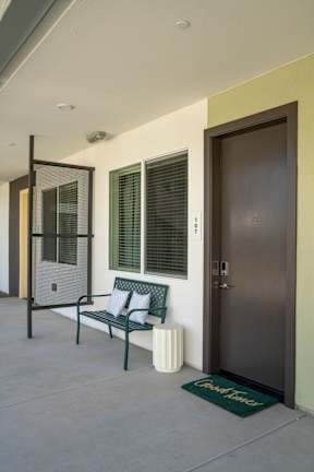 A brown door is on the right side of a white bench.