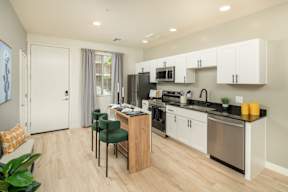 A kitchen with white cabinets and a wooden island.