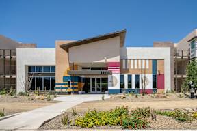 A modern building with a colorful facade and a clear blue sky in the background.