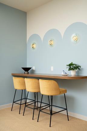 A table with three chairs and a bowl on it.