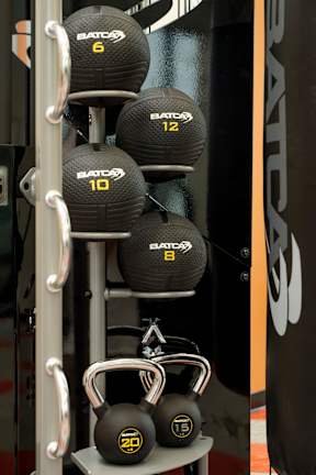 A set of BATCA kettlebells are displayed on a rack.