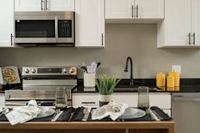 A modern kitchen with a stove, microwave, and oven.