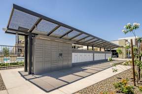 A modern building with a grey facade and a metal roof with a glass panel.