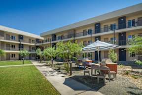 A sunny day at the outdoor seating area of a modern apartment complex.