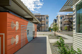 A modern building with orange and white walls and a balcony.