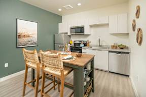 A kitchen with green walls and a wooden table.