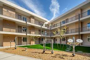 Apartment complex with a playground in the courtyard.
