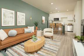 A living room with a brown couch, a coffee table, and a striped rug.
