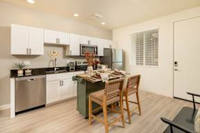 A kitchen with a table and chairs in the middle.
