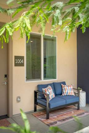 A blue couch with two pillows sits on a patio.