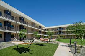 A modern apartment complex with a playground in the courtyard.